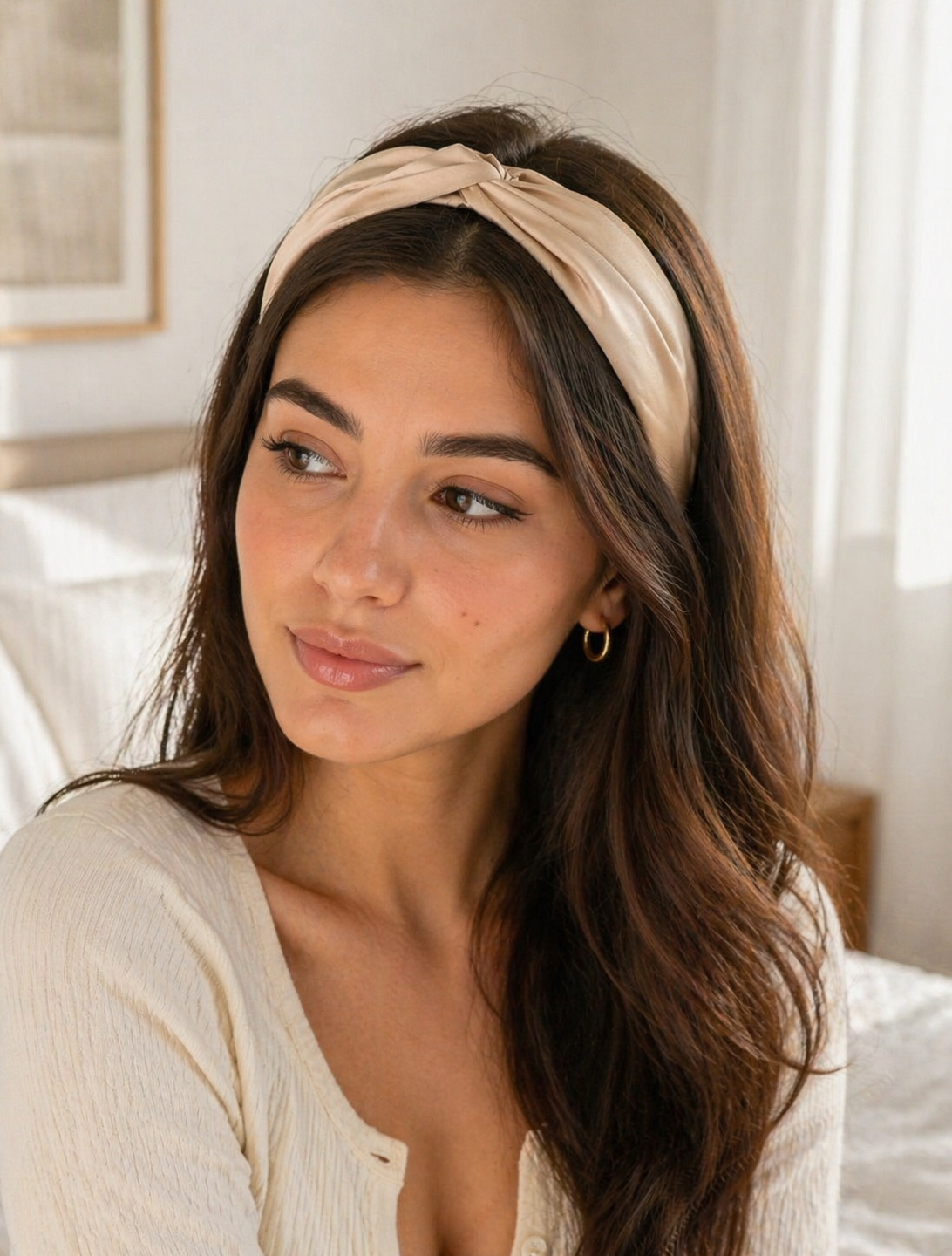 Woman wearing a beige headband in a bedroom setting